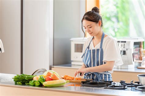 Attractive Japanese Woman Cooking In The Kitchen Stock Photo Download