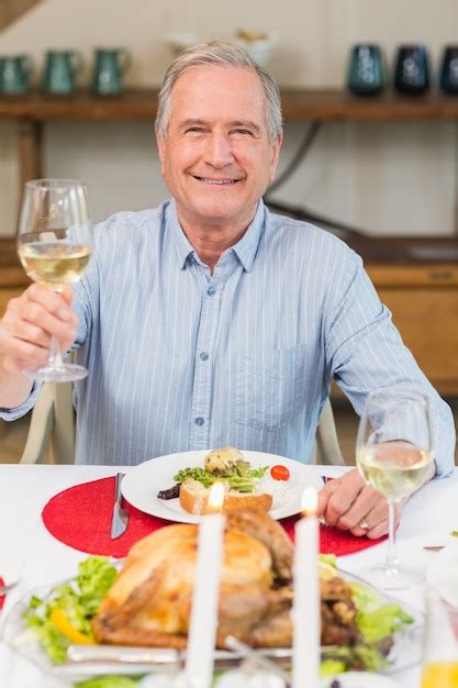 Premium Photo | Smiling man toasting at christmas dinner