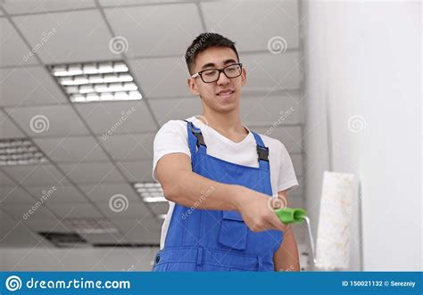 Pared Masculina De La Pintura Del Decorador Con El Rodillo Dentro Foto