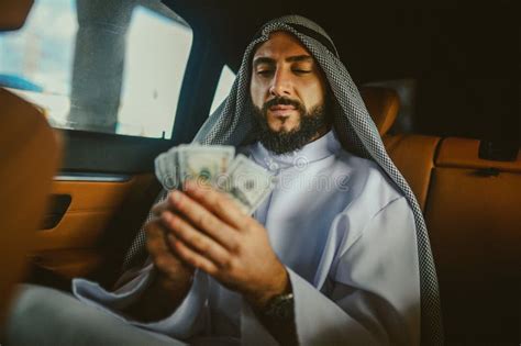 Saudi Man In A Traditional Clothing In A Car Holding Money Stock Image