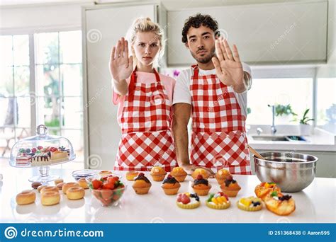 Couple Of Wife And Husband Cooking Pastries At The Kitchen Doing Stop Sing With Palm Of The Hand