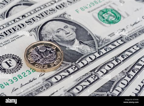 US dollar bills with a new, 12 sides, British / UK pound coin. One ...