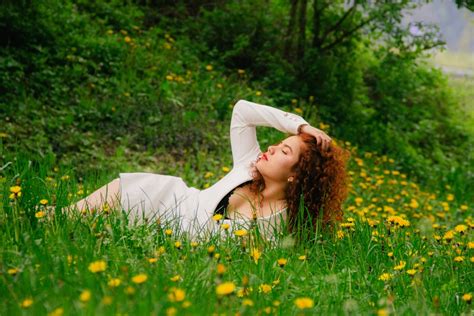 Une Femme Allongée Dans Lherbe Les Yeux Fermés Photo Photo Herbe