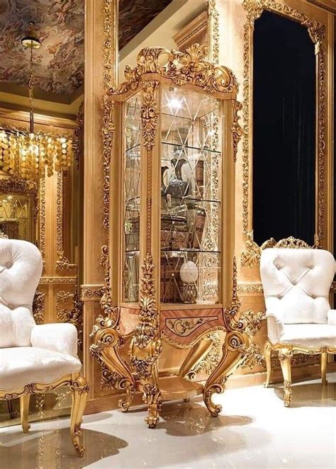 An Ornately Decorated Room With Gold Trimming And White Chairs