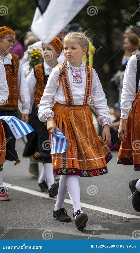 Estonian People In Traditional Clothing Walking The Streets Of Tallinn