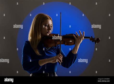 Beautiful Blond Girl Playing Violin Female Violinist Against Dark Blue Background With Smoke