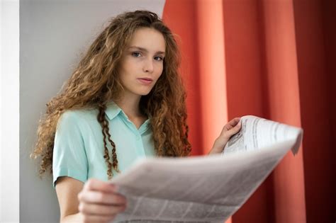 Mujer De ángulo Bajo Leyendo Periódico Foto Gratis