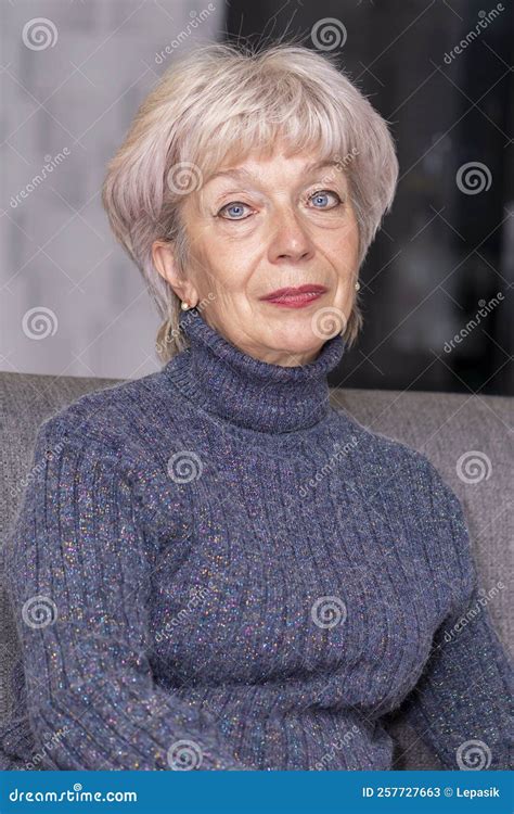 Portrait Of An Elderly Blonde Woman 60 65 Years Old Sitting On A Couch