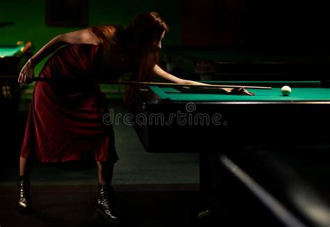 Young Woman Playing Billiards In The Dark Billiard Club Stock Image