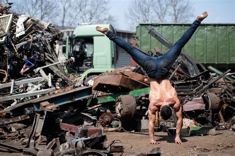 Premium Photo | Masculine man standing on his hands in junkyard