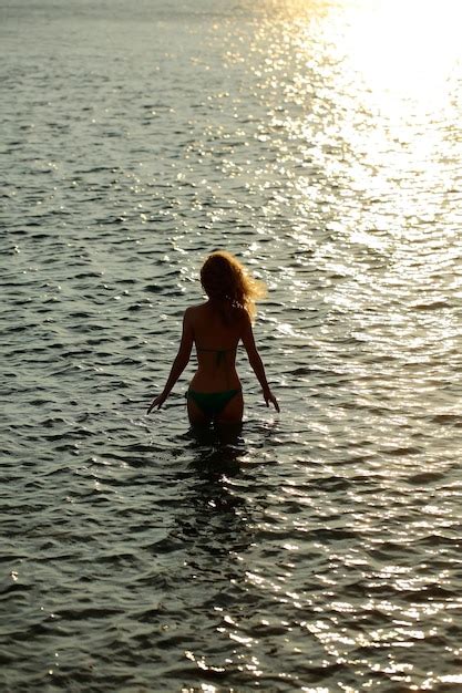 Premium Photo | Woman silhouette in sunset beach