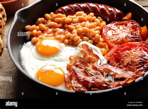 English Breakfast With Sausages Grilled Tomatoes Egg Bacon And Beans On Frying Pan Stock