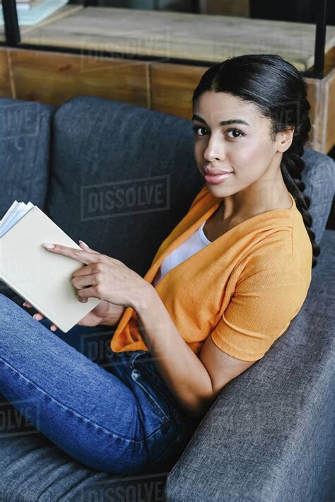 High Angle View Of Beautiful Mixed Race Girl In Orange Shirt Holding