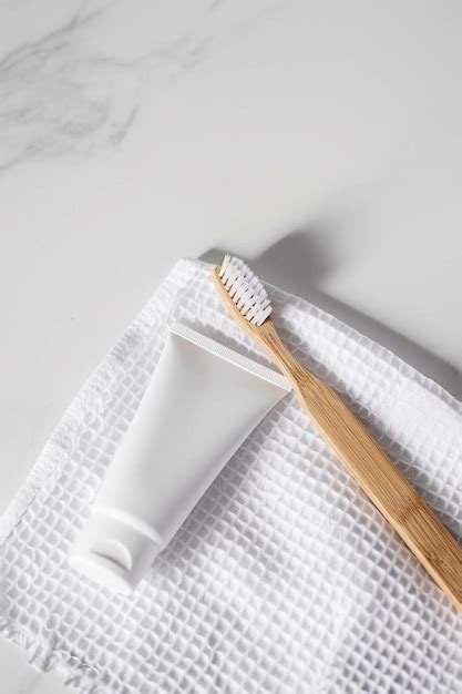 A Toothbrush Sitting On Top Of A Towel Next To A Tube Of Toothpas