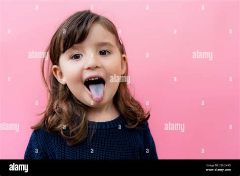 Petite fille qui tire la langue Banque de photographies et dimages à