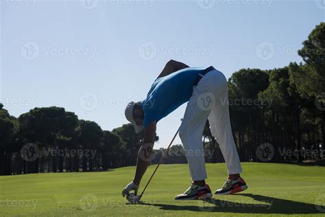 Golf Player Placing Ball On Tee Stock Photo At Vecteezy