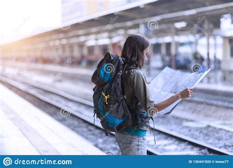 Backpacker De La Mujer Joven Que Mira El Mapa Para Planear Su Ruta Para