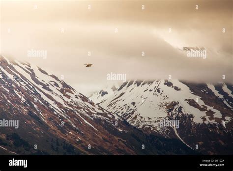 Small Plane Flying Through Mountains Near Moose Pass Alaska With Storm