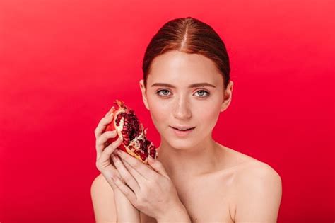 Free Photo Front View Of Adorable Woman Holding Ripe Garnet Studio