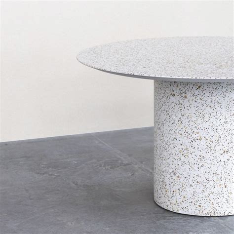 A White Table With Gold Speckles On It S Top Sitting On A Concrete Floor