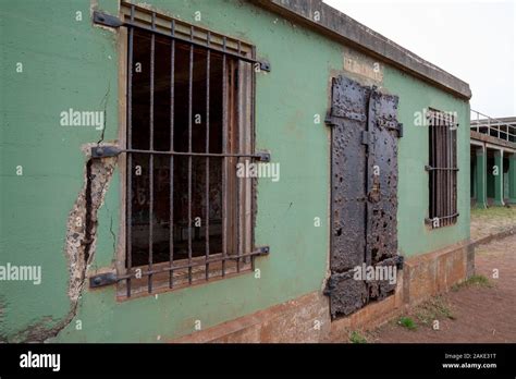 Green Broken Down Building With Rusted Metal Gates And Doors Stock