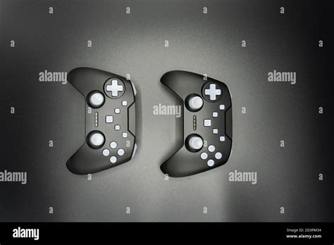 Two Black Game Joysticks With White Buttons Isolated On Gray Background