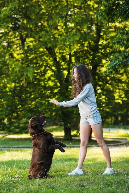 Belle Jeune Femme Jouant Avec Son Chien Dans Le Jardin Photo Gratuite