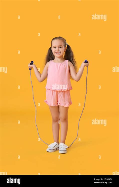 Cute Little Girl Jumping Rope Against Color Background Stock Photo Alamy