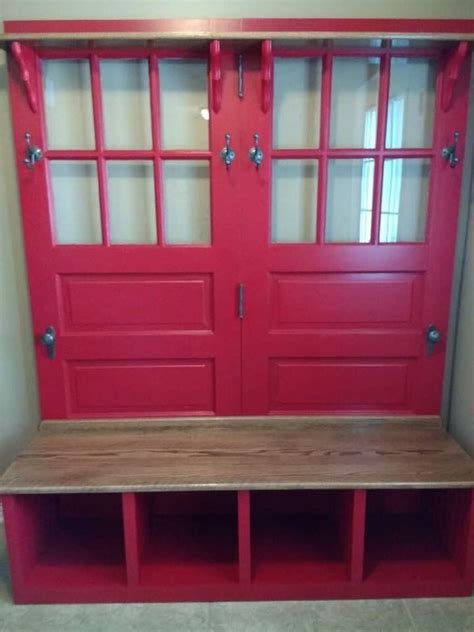 A Wooden Bench Sitting In Front Of A Red Door With Glass Panels On The