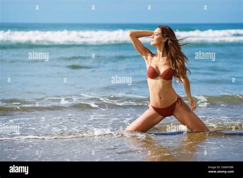 Junge Frau Im Bikini Kniet Am Strand Stockfotografie Alamy