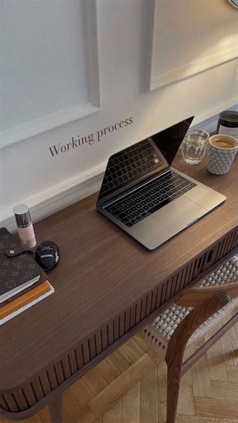 An Open Laptop Computer Sitting On Top Of A Wooden Desk Next To A Cup