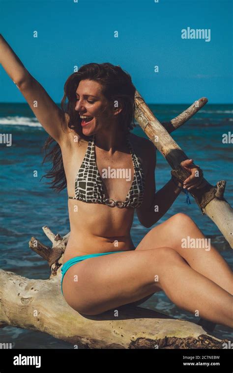 Une Jeune Femme Heureuse En Riant Dans Un Bikini Assis Sur Une Branche D Arbre En Face De La Mer