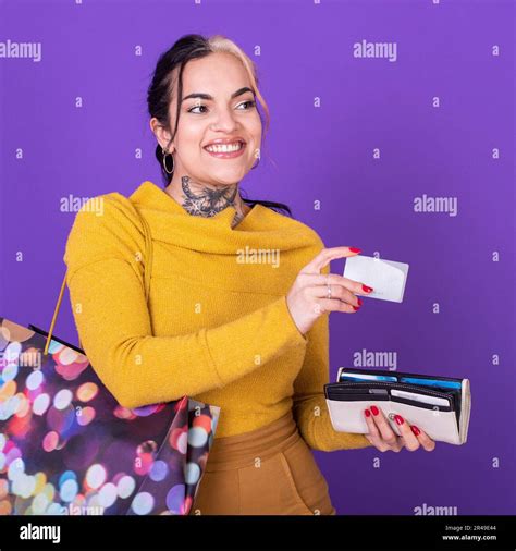 A Women Holding Her Wallet And Shopping Bag While Showing A Credit Card