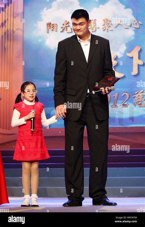 Retired Chinese Basketball Superstar Yao Ming Stands Next To A Young