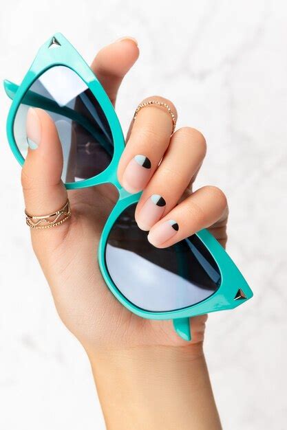 Premium Photo Beautiful Groomed Womans Hand With Nude And Blue Matte Nail Design Holding A