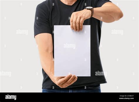 Man With Blank Paper Sheet On Grey Background Stock Photo Alamy