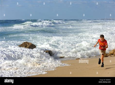 Boy Runs Along The Shore Stock Photo Alamy