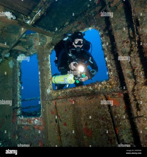 Diver views interior of shipwreck has special equipment for mixed gas ...