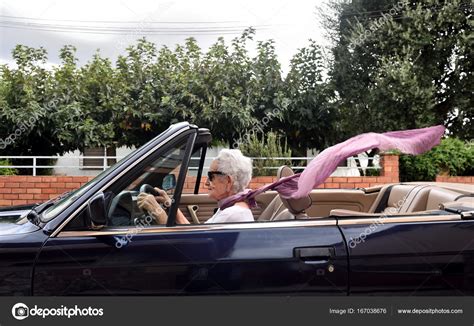 Old woman driving a convertible car — Stock Photo © MariaiC #167038676