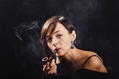 Het Brunette In Een Zwart Sweatshirt Rookt Een Pijp Stock Foto Image