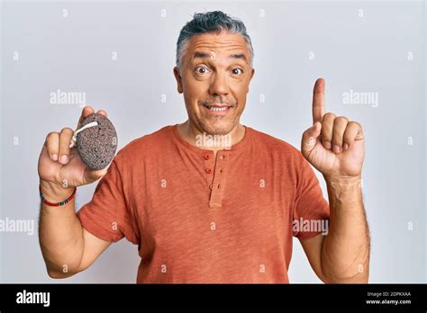 Handsome Middle Age Mature Man Holding Pumice Stone Smiling With An