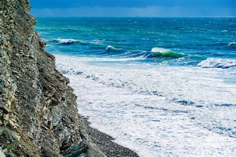 Penhascos Altos E Uma Praia Espumante Abaixo Lindas Ondas De