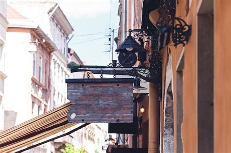 Premium Photo Vintage Wooden Sign Suspended On Gun On Wall Of Building