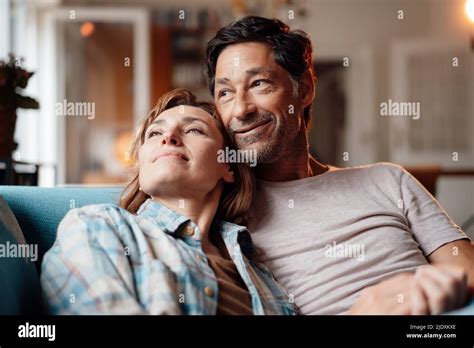 Smiling Mature Woman With Man Sitting On Sofa At Home Stock Photo Alamy