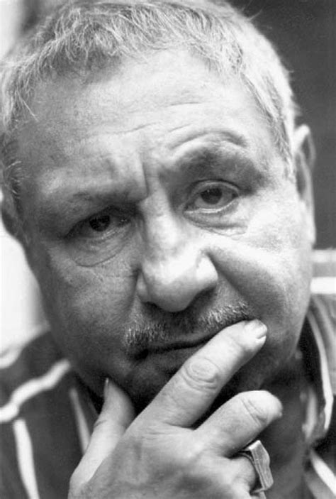 black and white photograph of a man with his hand on his chin looking ...