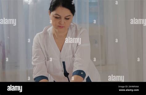 Woman Massage Therapist Does Massage On The Calf Muscles Of A Young