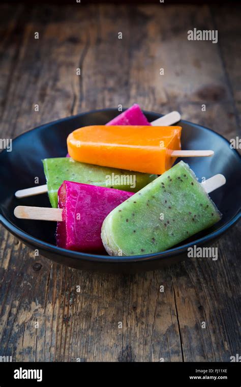 Bowl Of Fruit Smoothie Ice Lollies On Dark Wood Stock Photo Alamy