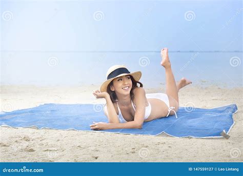 Fille Sexy Asiatique Dans Le Bikini Et Le Chapeau Se Trouvant Sur Le Tapis En Plage Image Stock