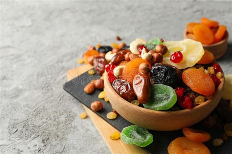 Tabla Y Cuencas Con Frutos Secos Y Nueces En Fondo Gris Imagen De