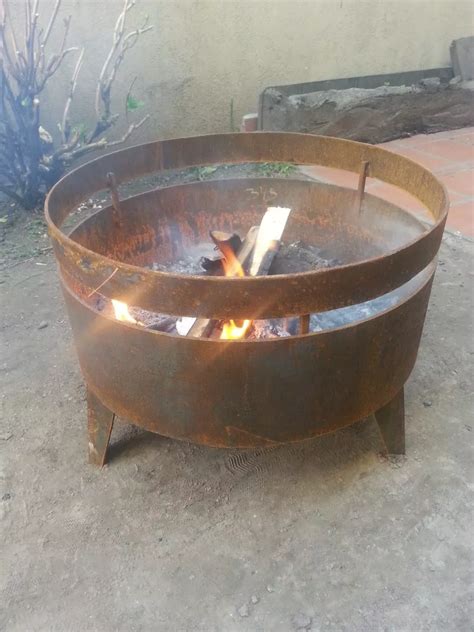 A Fire Pit Sitting On Top Of A Cement Ground